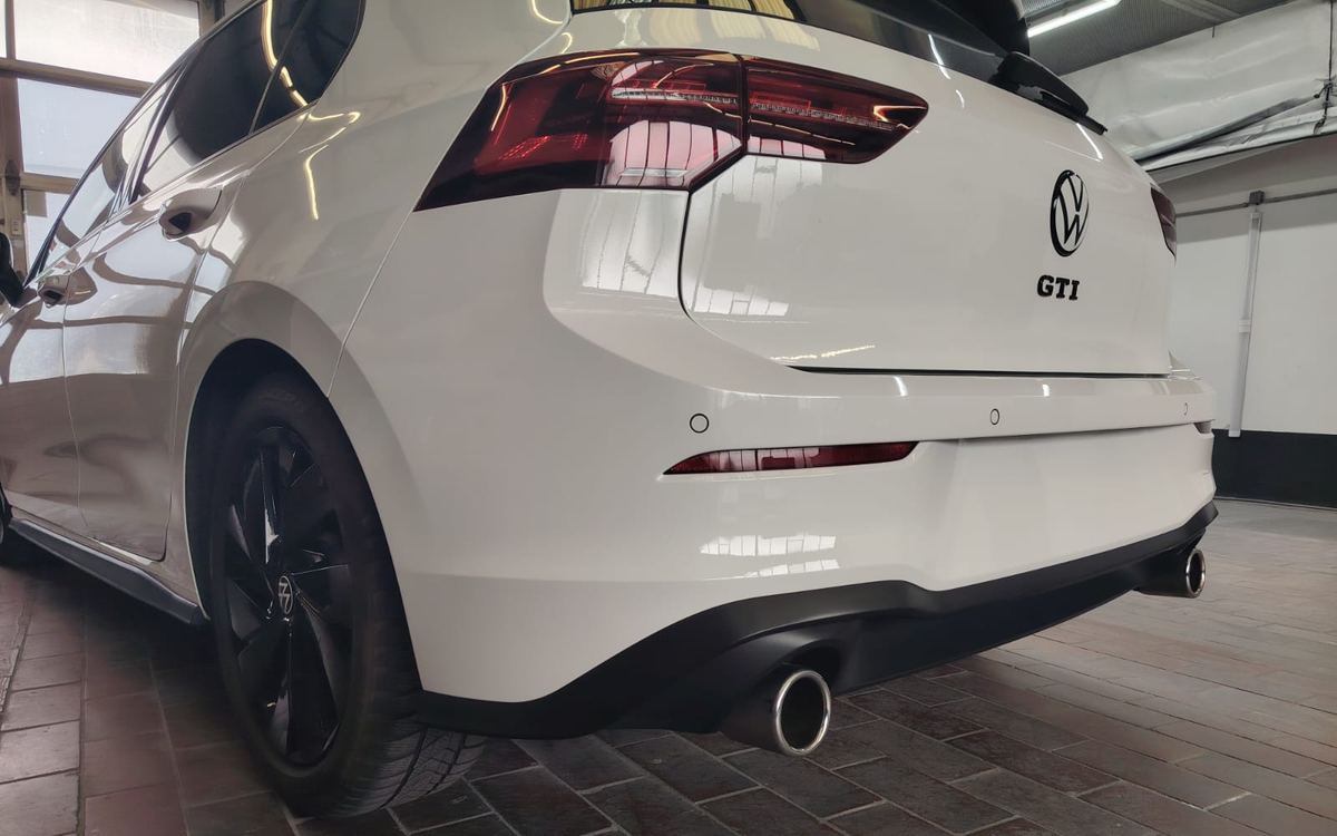 Derselbe Golf GTI aus gleicher Perspektive in der Werkstatt, Heckstoßstange instand gesetzt und frisch lackiert